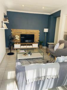 een woonkamer met een bank en een tv bij Place on Oak 4 in Bulawayo