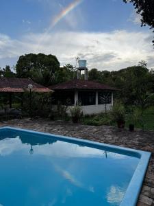 een regenboog boven een huis met een zwembad bij Sitio ecológico para eventos in Benevides