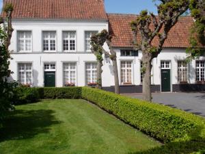 a hedge in front of a white building at B&B De Grote Plaats in Hoogstraten