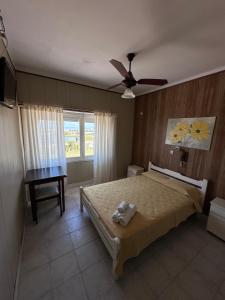 een slaapkamer met een bed en een plafondventilator bij Hotel Saona in Mar del Plata
