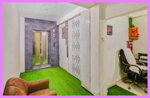 ein Büro mit grünem Teppich und einem Stuhl und einem Schreibtisch in der Unterkunft Hotel Satvik Premium Near Park in Bhubaneshwar