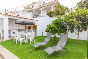a patio with a table and chairs on grass at D02 - Carrob Street House in Lagos