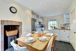 una cucina con tavolo in legno e camino di 4 Bed in St. Mawgan oc-p00610 a Saint Mawgan
