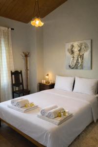 een slaapkamer met een groot bed, handdoeken en een schilderij van een olifant bij Horizon Nest Parnassos Villa Chalet! in Eptalofos