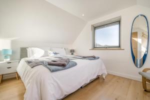 a white bedroom with a large bed and a mirror at 2 Bed in Crackington Haven oc-h33817 in Crackington Haven