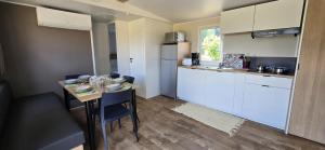 カンソンにあるCamping - Piscine - ccbbabdの小さなキッチン(テーブル、椅子付)、