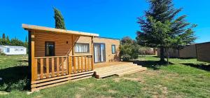 カンソンにあるCamping - Piscine - ccbbabdの芝生の上にデッキがある木造キャビン