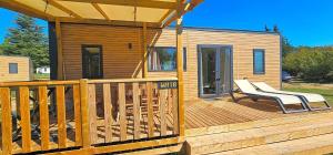 カンソンにあるCamping - Piscine - ccbbabdのデッキ(ベンチ付)が備わるキャビン