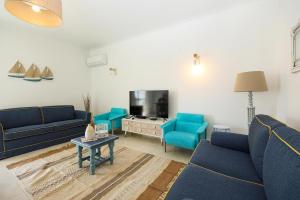 a living room with blue couches and a tv at C13 - Ameijeira Holiday Apartment in Lagos in Lagos