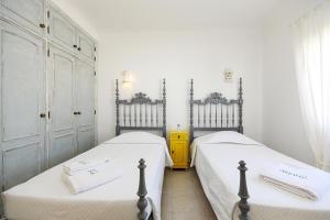 two twin beds in a room with white walls at C13 - Ameijeira Holiday Apartment in Lagos in Lagos