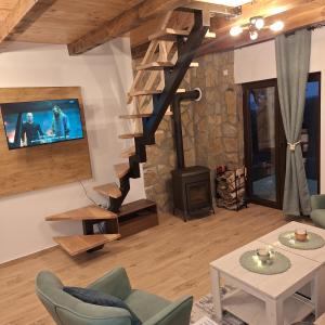 a living room with a wood stove and a tv at Brvnara Gorska Dama in Sekulić 