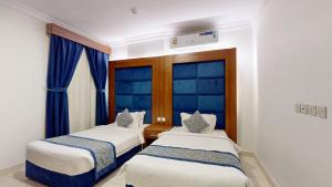 麦地那أونيسن المدينة的带2张床的蓝色窗户客房 更多56张照片