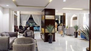 麦地那أونيسن المدينة的大厅里摆放着沙发和椅子，一个人走进房间