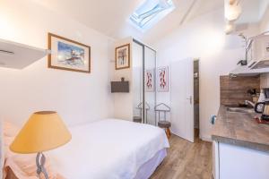 une chambre avec un lit blanc et un lavabo dans l'établissement Chambre d'hôtes-studette Biarritz Milady, calme, patio, vue sur jardin et montagne du patio, parkin privé, tout confort, à Biarritz