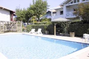 une piscine avec deux chaises et un gazebo dans l'établissement Chambre d'hôtes-studette Biarritz Milady, calme, patio, vue sur jardin et montagne du patio, parkin privé, tout confort, à Biarritz