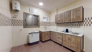a kitchen with a sink and a refrigerator at شقق أون يسن للشقق المخدومة in Medina