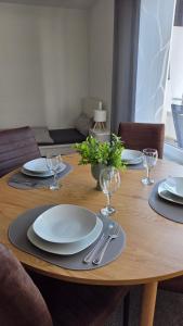 un tavolo di legno con sopra piatti e bicchieri da vino di MaxMir - Tannenweg Iserlohn a Iserlohn Altre 10 foto