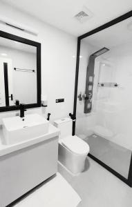 a bathroom with a sink and a toilet and a mirror at Alyraa sunset in Mathiveri