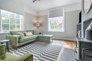 a living room with a green couch and a rug at 3 Bed in Cyfronydd oc-e32742 in Llanfair Caereinion