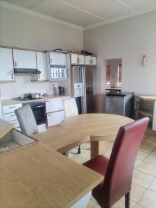 een keuken met een houten tafel en stoelen bij Brando bnb in Koning Willemstad