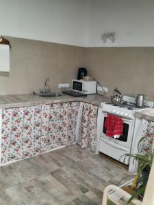 eine Küche mit einem weißen Herd und einer Mikrowelle in der Unterkunft Casa de ensueño a pasos del mar in Camet Norte