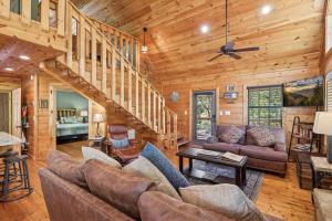 een woonkamer met banken en een trap bij The Wild Life cabin in Hatchertown