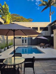 una mesa con sombrilla junto a la piscina en SBS Hotel & Spa, en Asunción