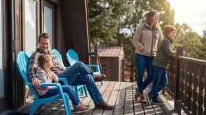 a man and a woman and two children on a porch at Rustic Mountain Getaway~Golf~Skiing~Hiking in Angel Fire