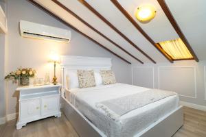 a bedroom with a white bed and a white nightstand at Casa García in Guayaquil