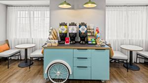 ヴェスタルにあるSpark by Hilton Vestal Binghamton University Areaのスツールのある部屋に青いカートがあるバー