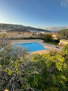 een zwembad in de tuin van een huis bij Studio avec canapé lit 2 places dans pièce de vie et lit une place dans coin nuit in Saint-Mandrier-sur-Mer