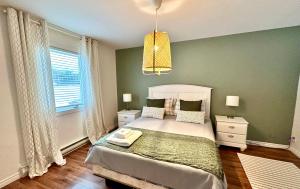 een slaapkamer met een groot bed en een raam bij Condos Mont-Trinité in Saint-Michel-des-Saints