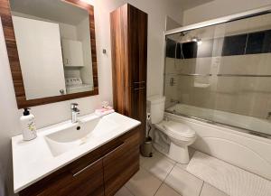een badkamer met een wastafel, een toilet en een spiegel bij Condos Mont-Trinité in Saint-Michel-des-Saints +18 foto's