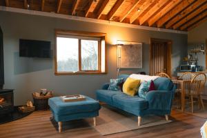 a living room with a blue couch and a table at The Bothy at Coneloch in Elgin