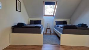 due letti in una piccola stanza con una finestra di MaxMir - Ortlohn Iserlohn a Iserlohn
