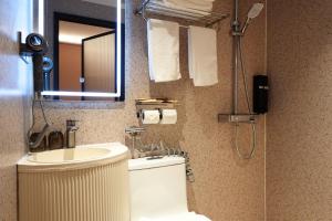 a bathroom with a toilet and a sink and a mirror at Hotel 165 - Newly Renovated in Singapore