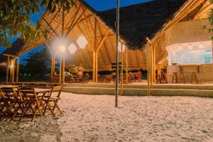 een groep tafels en stoelen voor een gebouw bij Bio-Resort Camping in Trairi