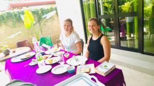 two people sitting at a table with a purple table cloth at TIKITIBE Villa & Restaurant in Hiriketiya +35 photos