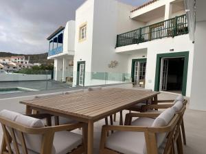 een houten tafel en stoelen op het balkon van een huis bij Luxury Home Estefania in Chayofa