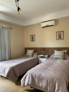 zwei nebeneinander stehende Betten in einem Schlafzimmer in der Unterkunft Linda Vista en Adrogue in Adrogué