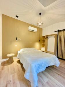 a bedroom with a large white bed and a table at Les Jardins Bas in Moulins