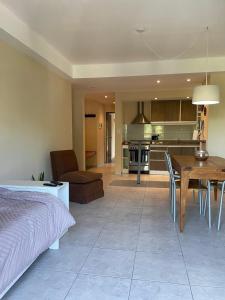 ein Wohnzimmer und eine Küche mit einem Bett und einem Tisch in der Unterkunft Linda Vista en Adrogue in Adrogué