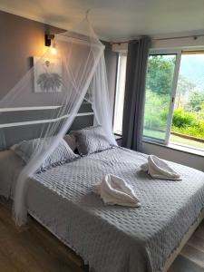 a bedroom with a bed with white sheets and a window at casa do campo in Machico