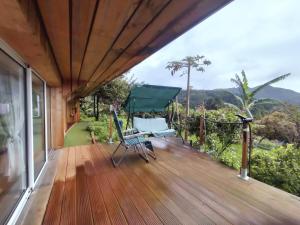 a wooden deck with a view of the mountains at casa do campo in Machico
