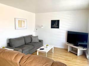 een woonkamer met een bank en een flatscreen-tv bij Condos Mont-Trinité in Saint-Michel-des-Saints