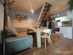 a living room and kitchen with a table and a staircase at Bieszczadzkie Pola in Wańkowa