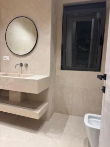 une salle de bains avec un lavabo et un miroir dans l'établissement Tirana Square Apartments, à Tirana 24 autres photos