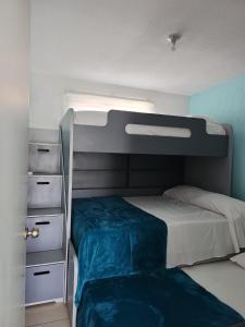 a bedroom with a bunk bed with a blue wall at Casa Lisboa in Puerto Vallarta