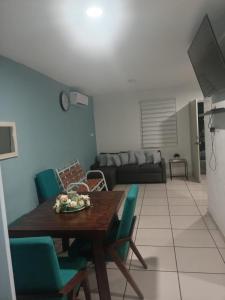 a living room with a wooden table and blue chairs at Casa Lisboa in Puerto Vallarta