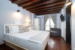 a bedroom with a white bed and a chair at Casa García in Guayaquil